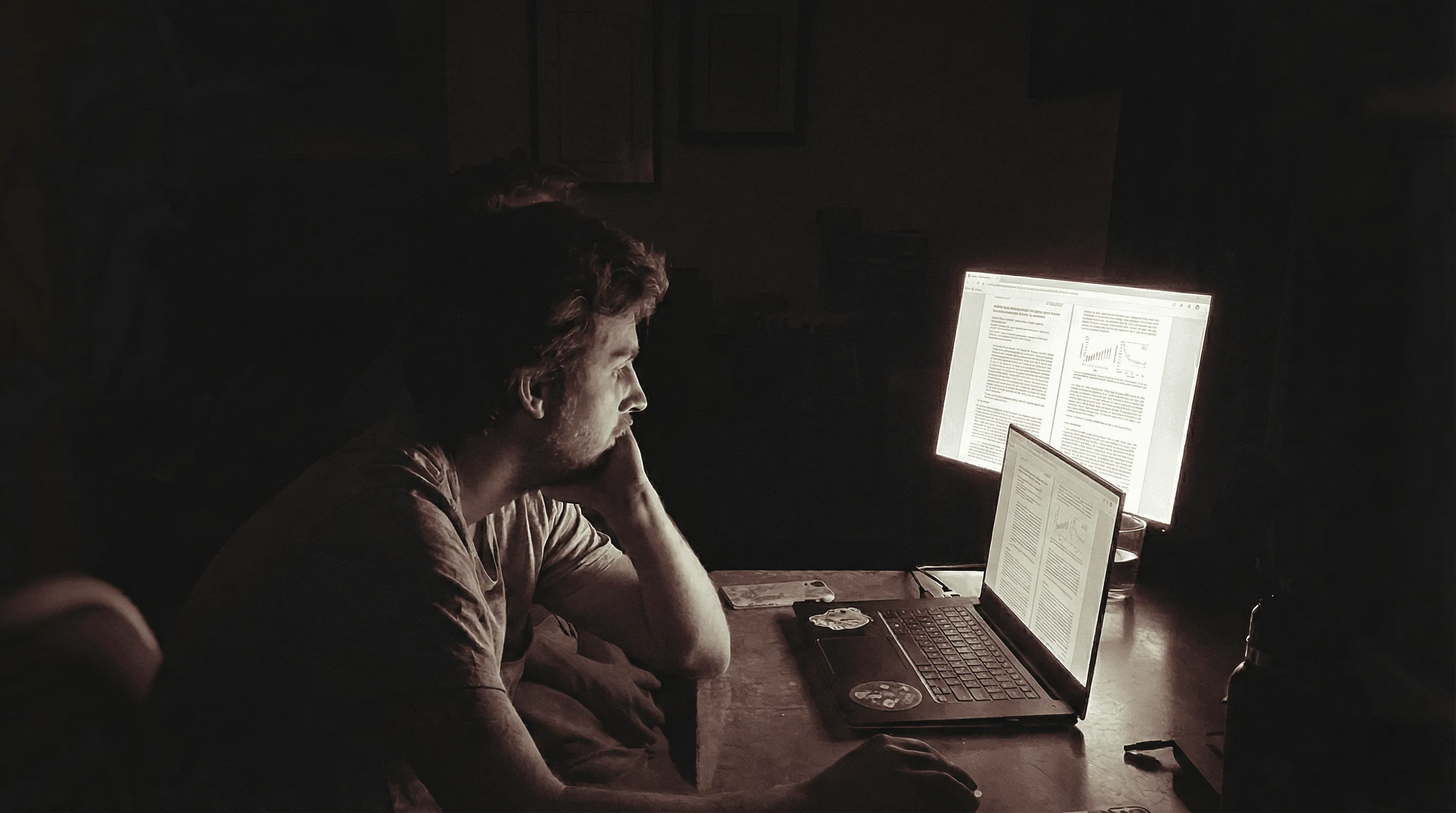 A student studying late at night in front of a laptop